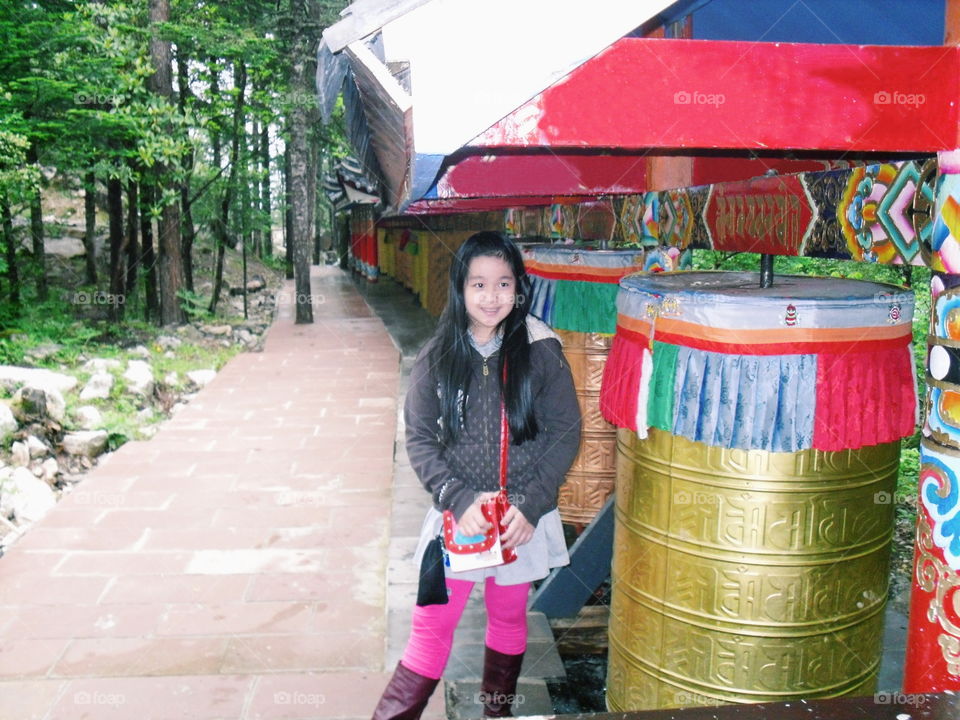 My sweetheart standing next to a huge colorful prayer wheel in China