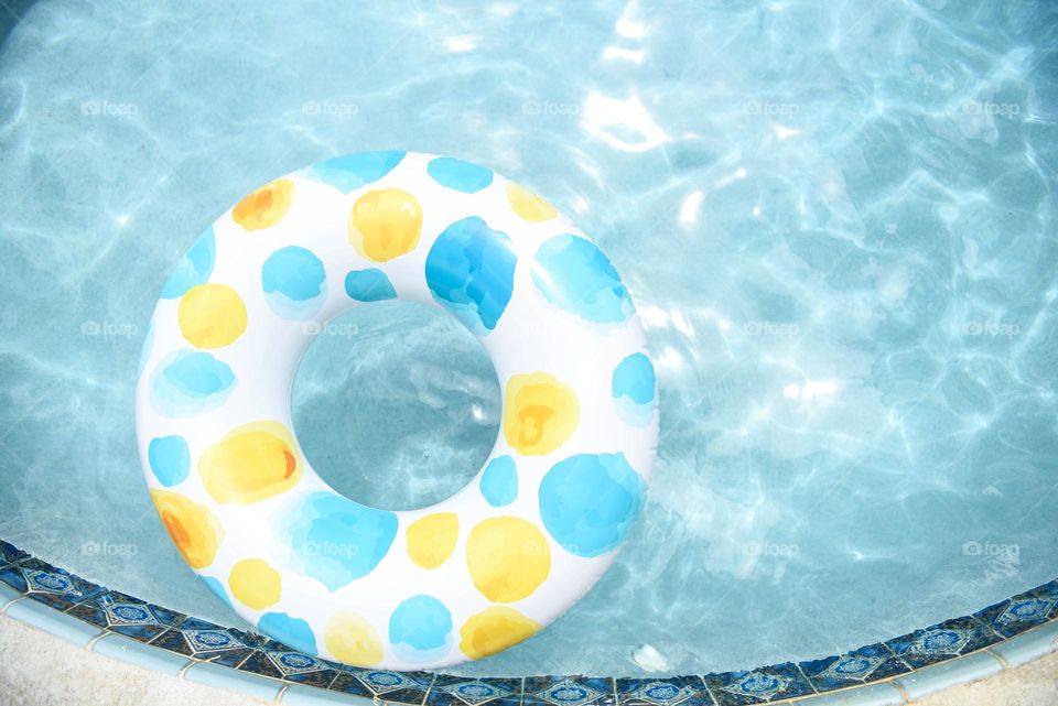 Blue spotted inner tube float in a blue sparkling swimming pool 