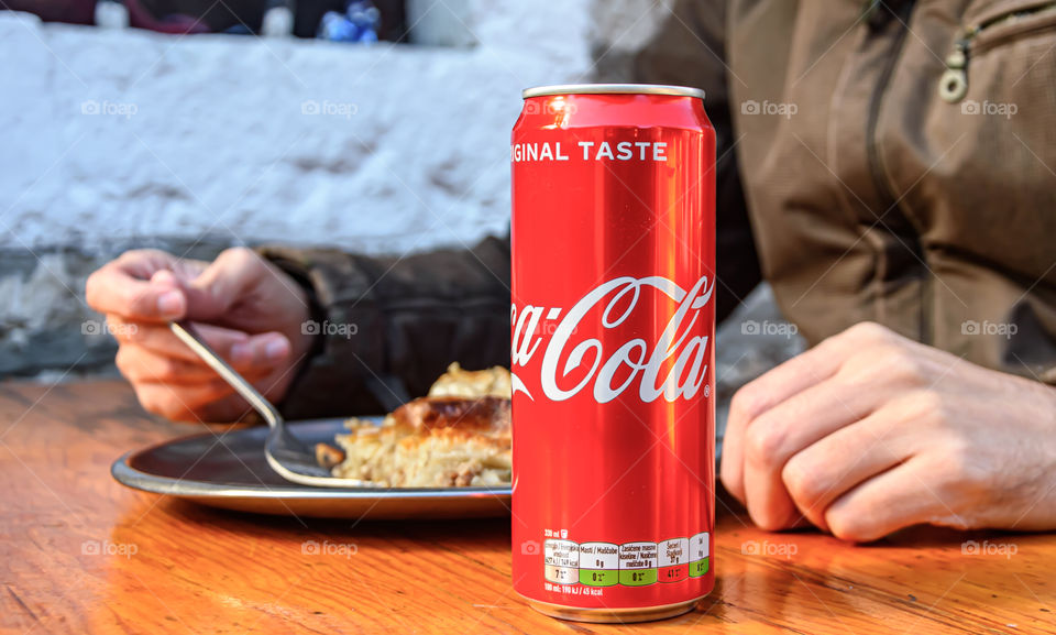 Man eating burek and drink Coca-Cola