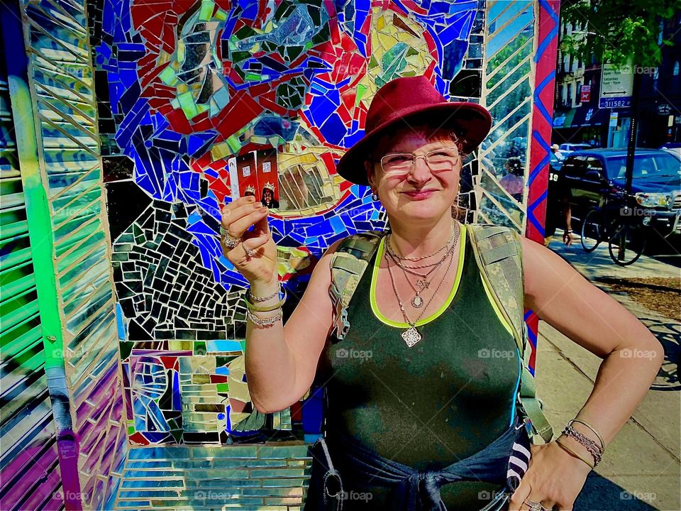 „Petra Schiller“, the photographer proudly holding up the commemorative metro cards imprinted with the image of famous as well as „notoriously acclaimed“ gangsta rapper „Christopher Wallace“ a.k.a. the „Notorious B.I.G.“. 2022. Hypnotic Productions