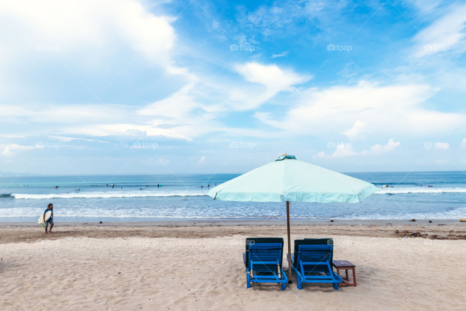 Sun loungers with umbrella on the Indian Ocean. Kuta beach, Bali island.