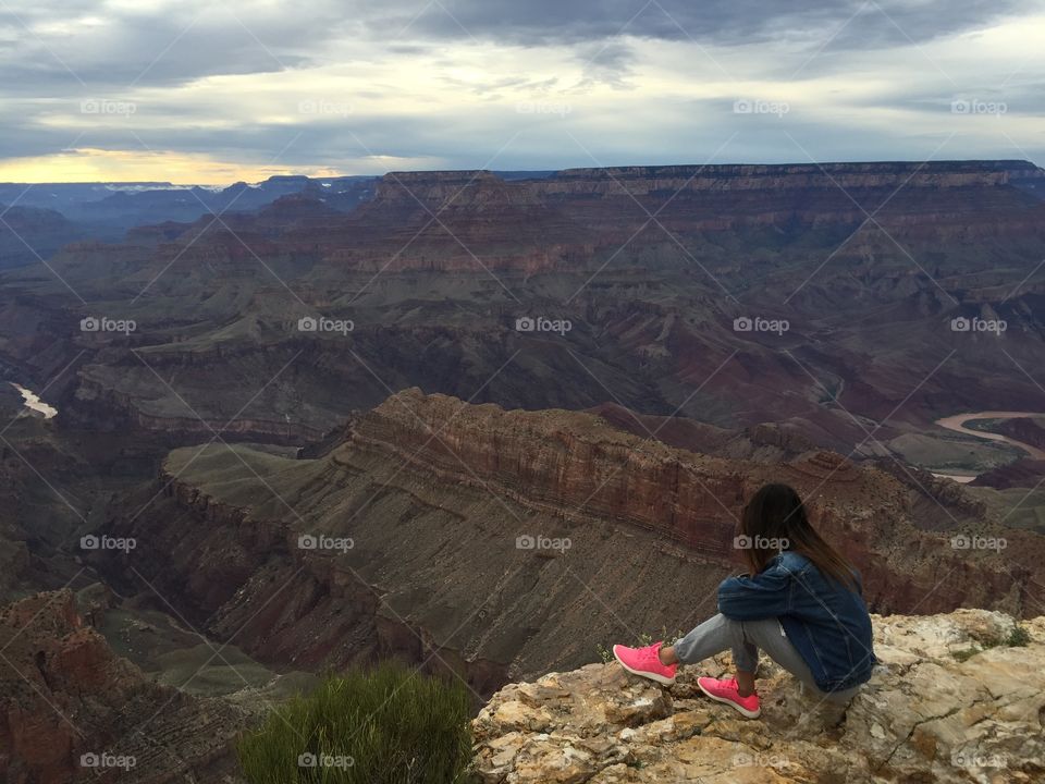 Woman takes a rest to look the Colorado river at the Grand Canyon