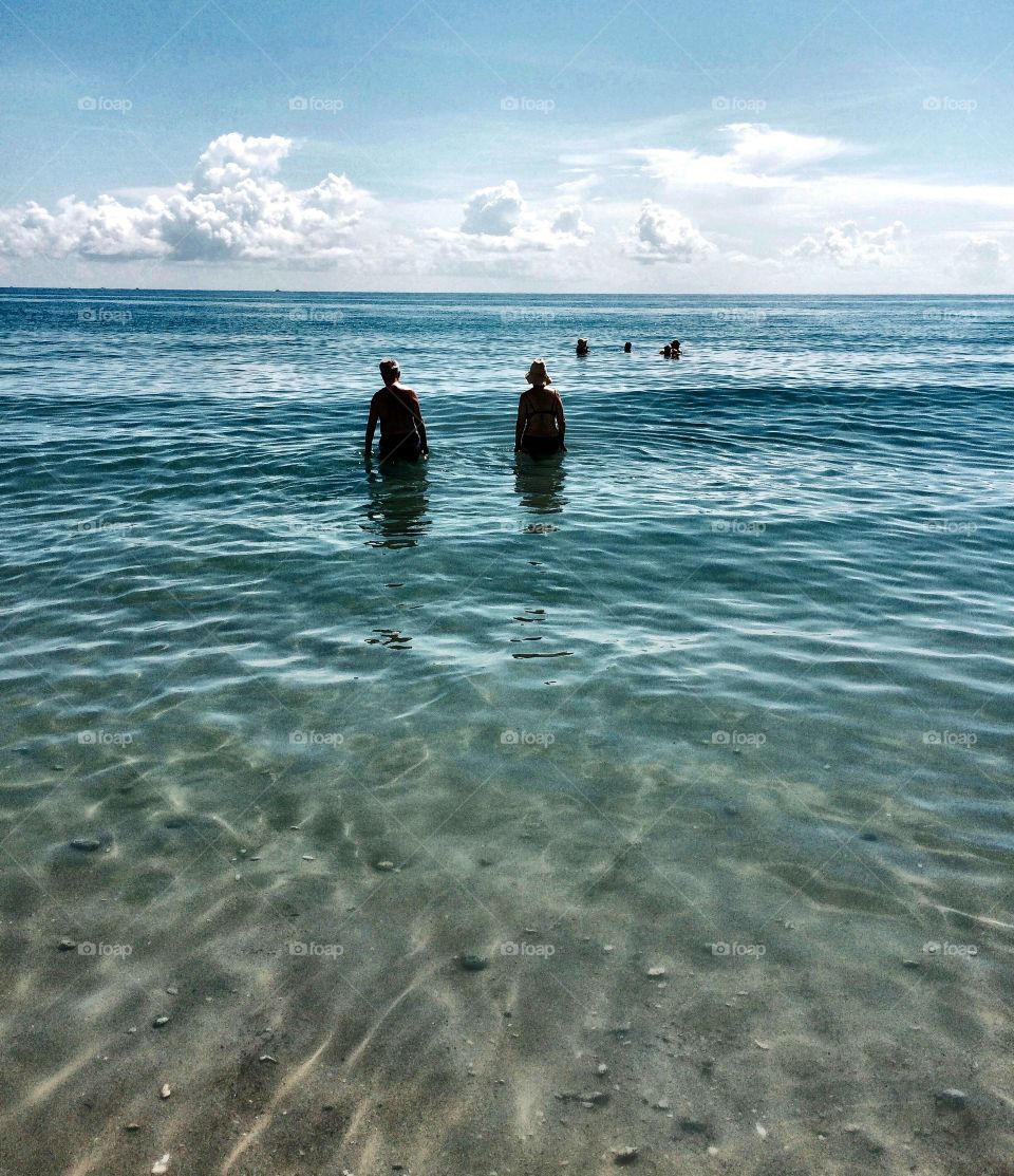 Older Couple Walk into the Sea