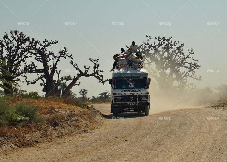 Passengers ride on top of a bus with the luggage! 