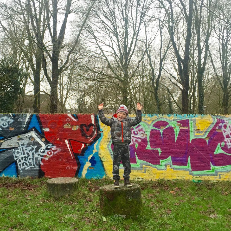 Child on graffiti wall