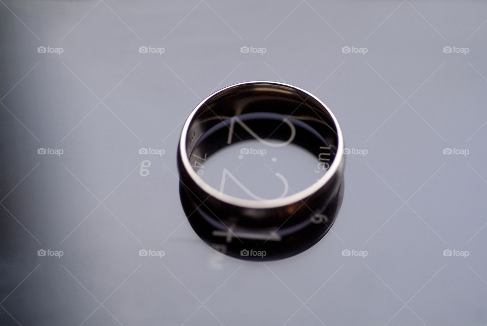 A wedding band sits atop a cell phone.