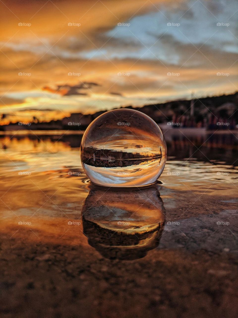 Top view of lensball,  crystal ball at the Adriatic seaside against sunset sky close up