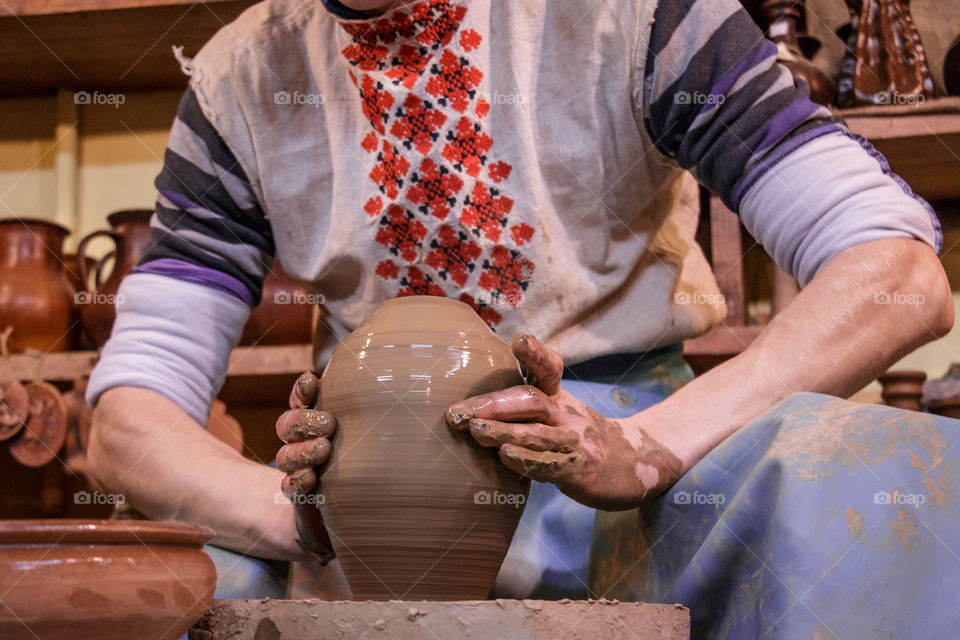 Learning pottery - man making a pot of clay