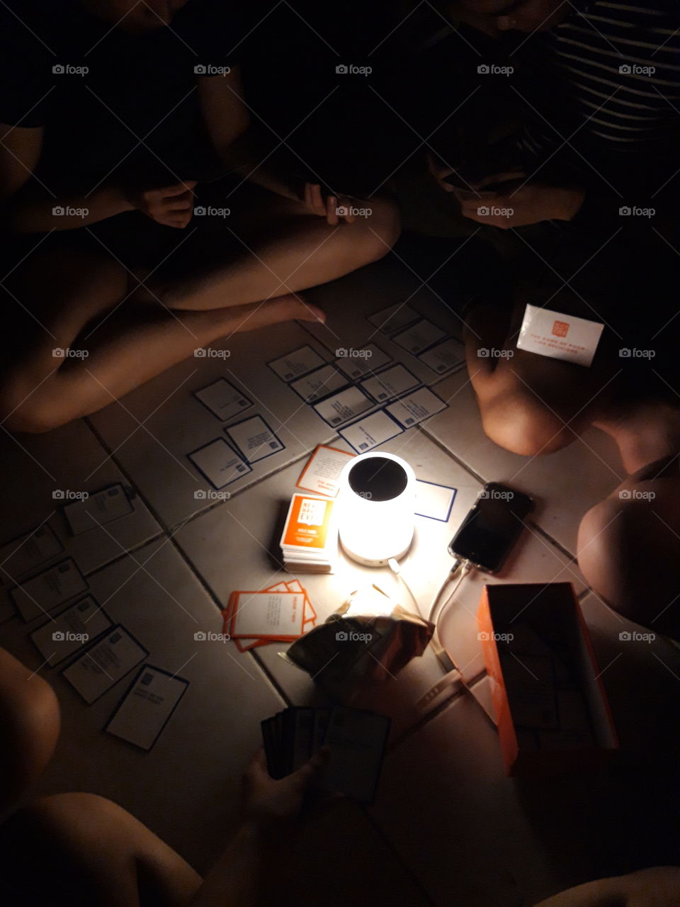 A card game night with friends around a lamp