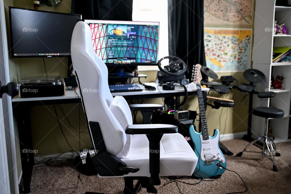 Teenage boy’s room desk and gaming area with musical instruments 
