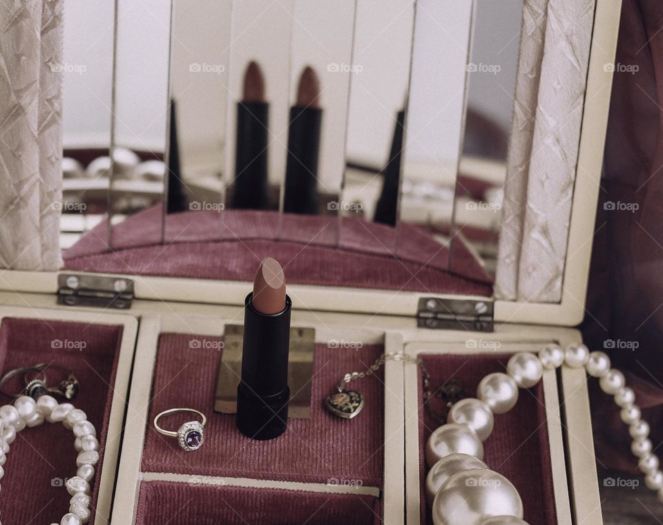 Vintage mirrored jewellery box with lipstick and pearls