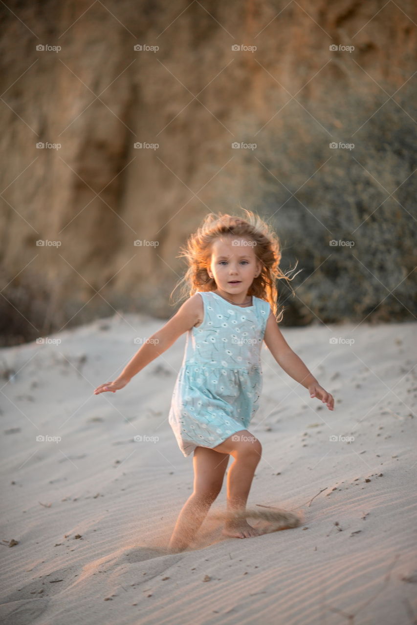 Little girl playing in the sand 