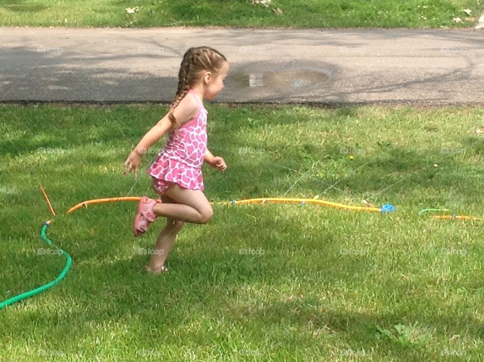 Sprinkler Time. My daughter running through the sprinkler