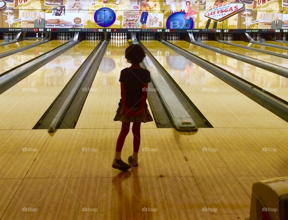 Little girl learning how to bowl