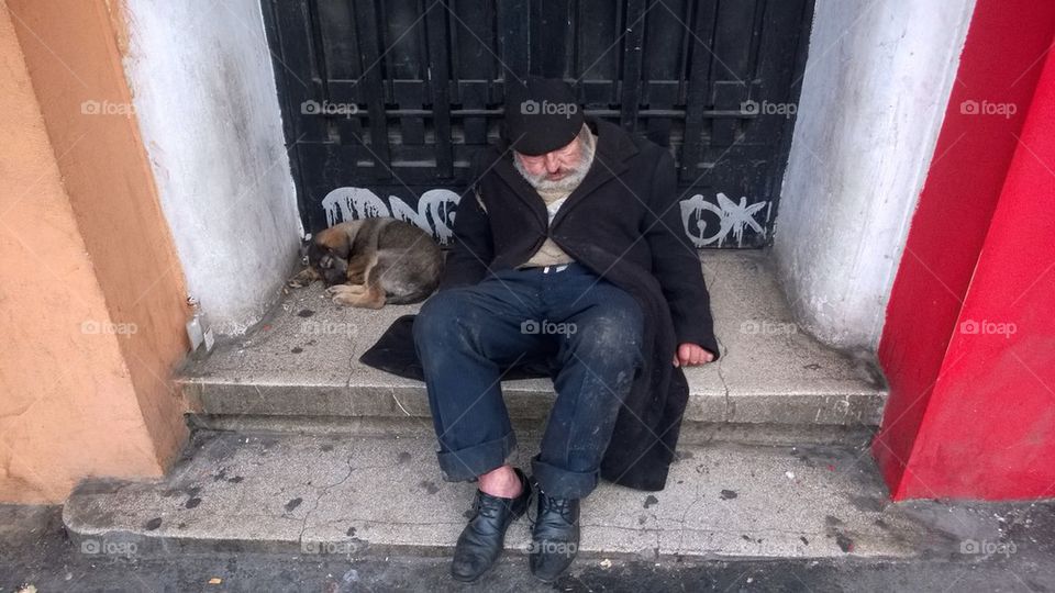 Homeless man sleeping with his dog