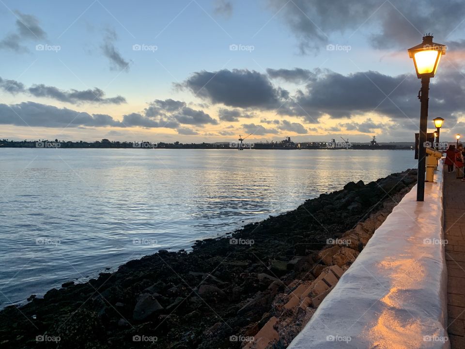 Walking along the waterfront at sunset with a view of the island.  