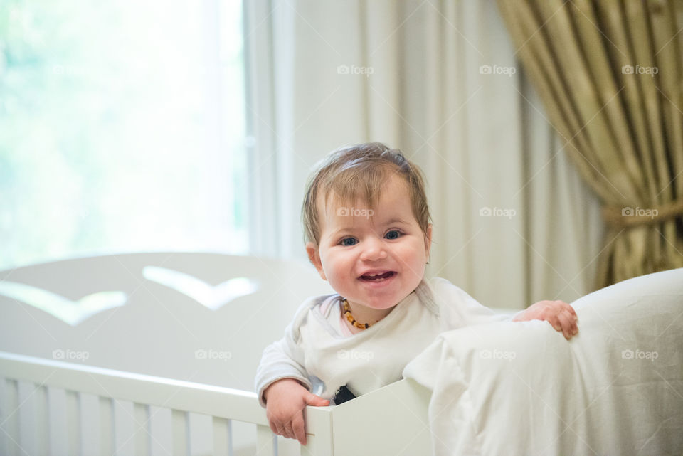 cute baby standing in her bed