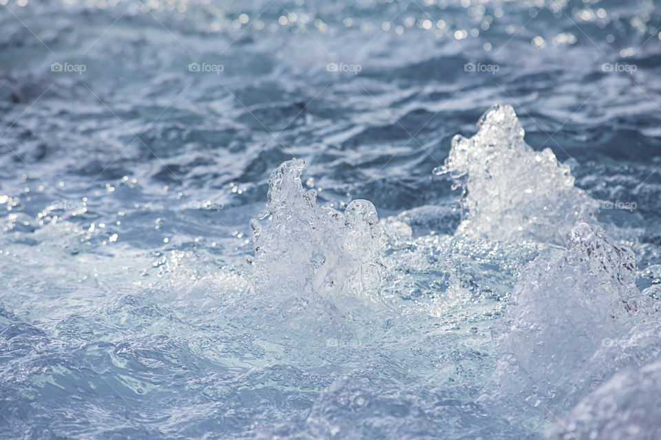 The blue water waves by wind and sunlight reflecting surface