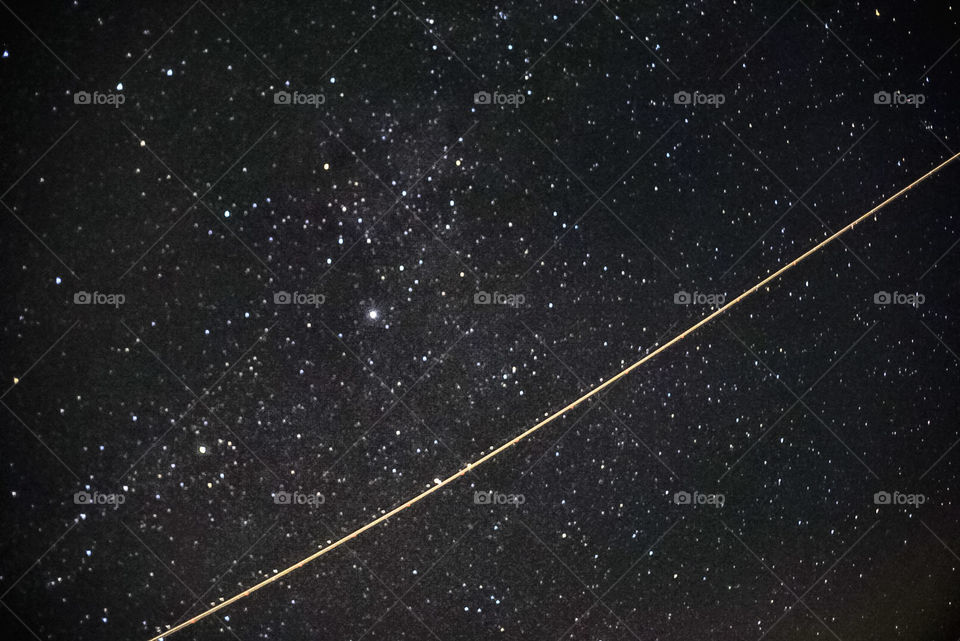 Milky Way Galaxy with a plane crossing the field of view