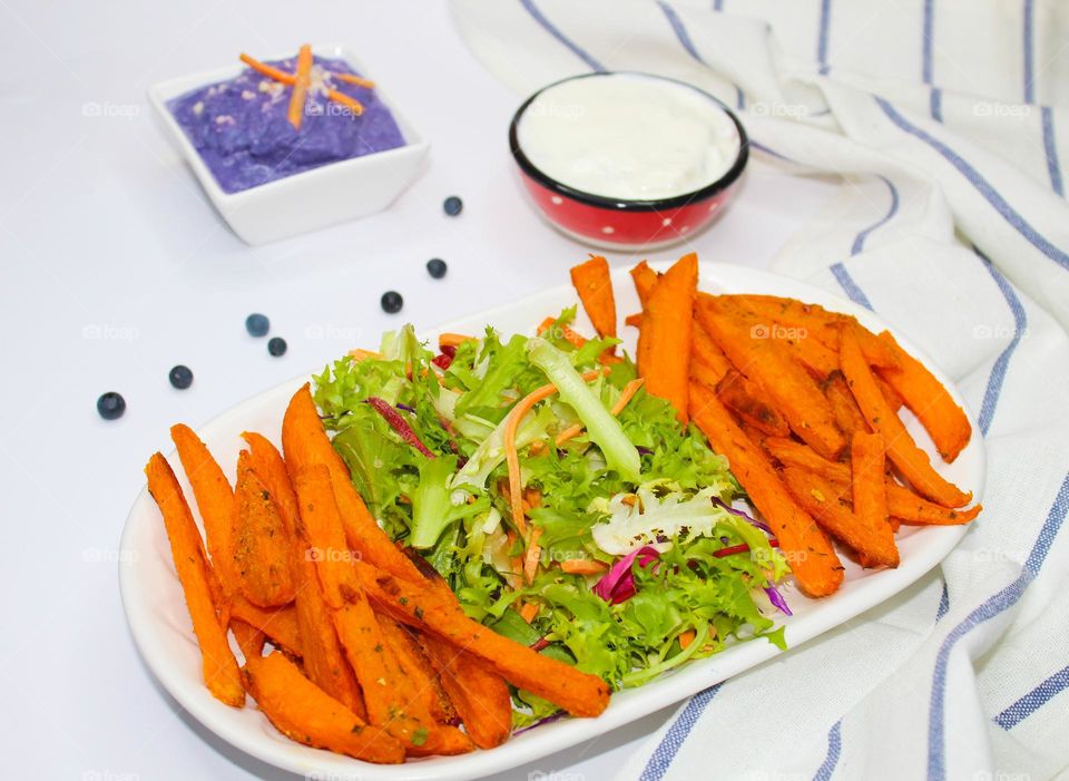 Sweet potato with mixed salad on a white plate