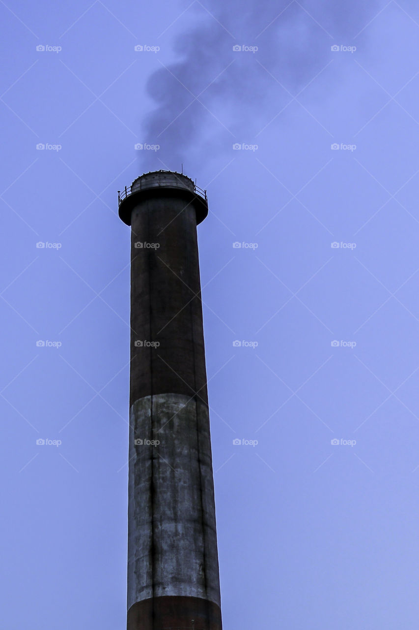 Exterior of maintenance and ventilation on top of a smoke tunnel, chimney for ventilation. Isolated old aged weathered tall industrial factory chimney grungy smokestack grunge vintage closeup blue sky