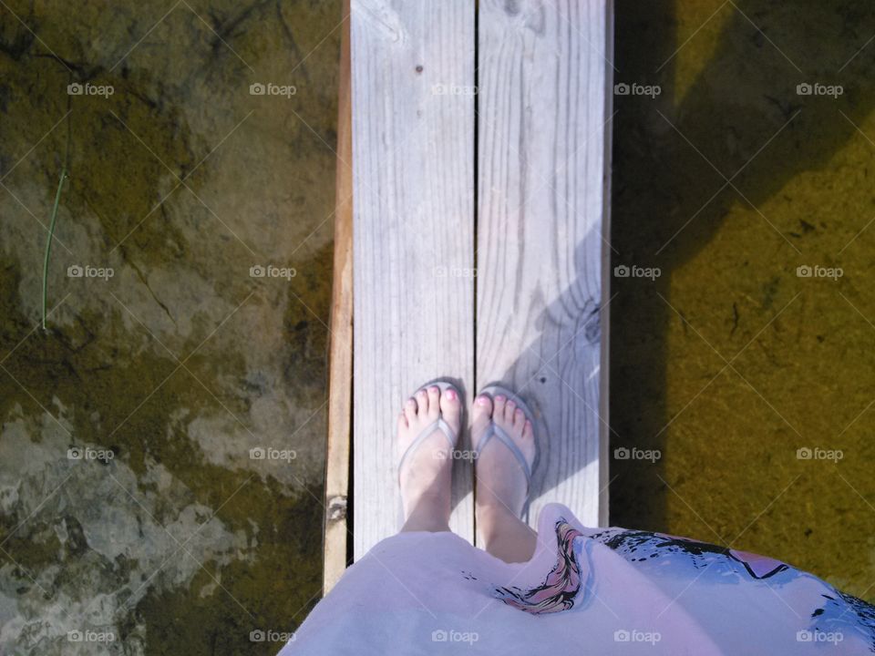 crossing water. feet on a narrow bridge over water