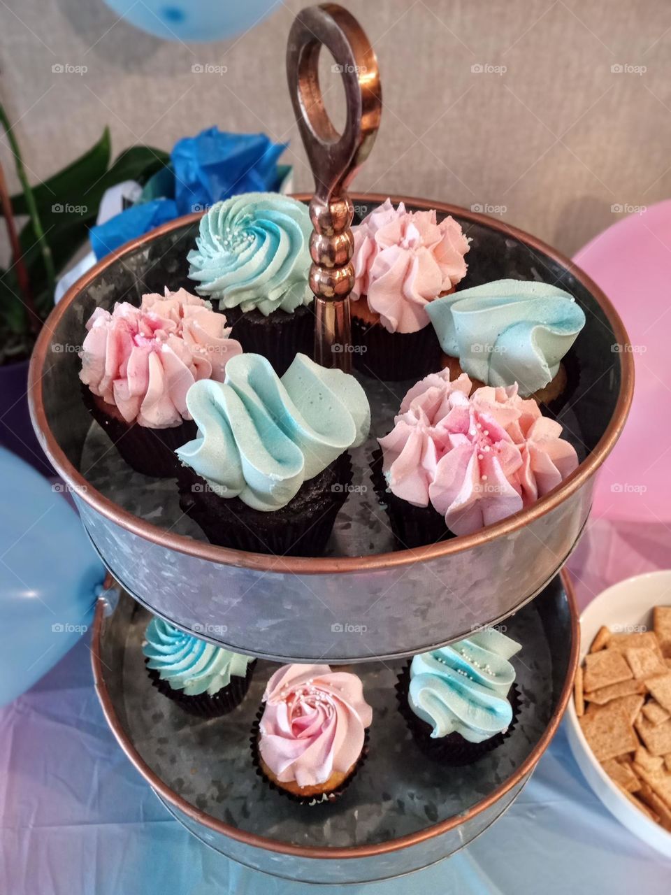 Gender reveal party time! A tower of yummy baby pink and blue frosted cupcakes. Is it a girl or a boy???