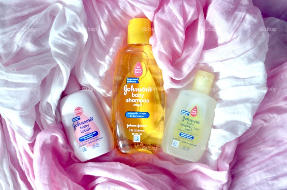 Johnson and Johnson baby products on a pink background flat lay 