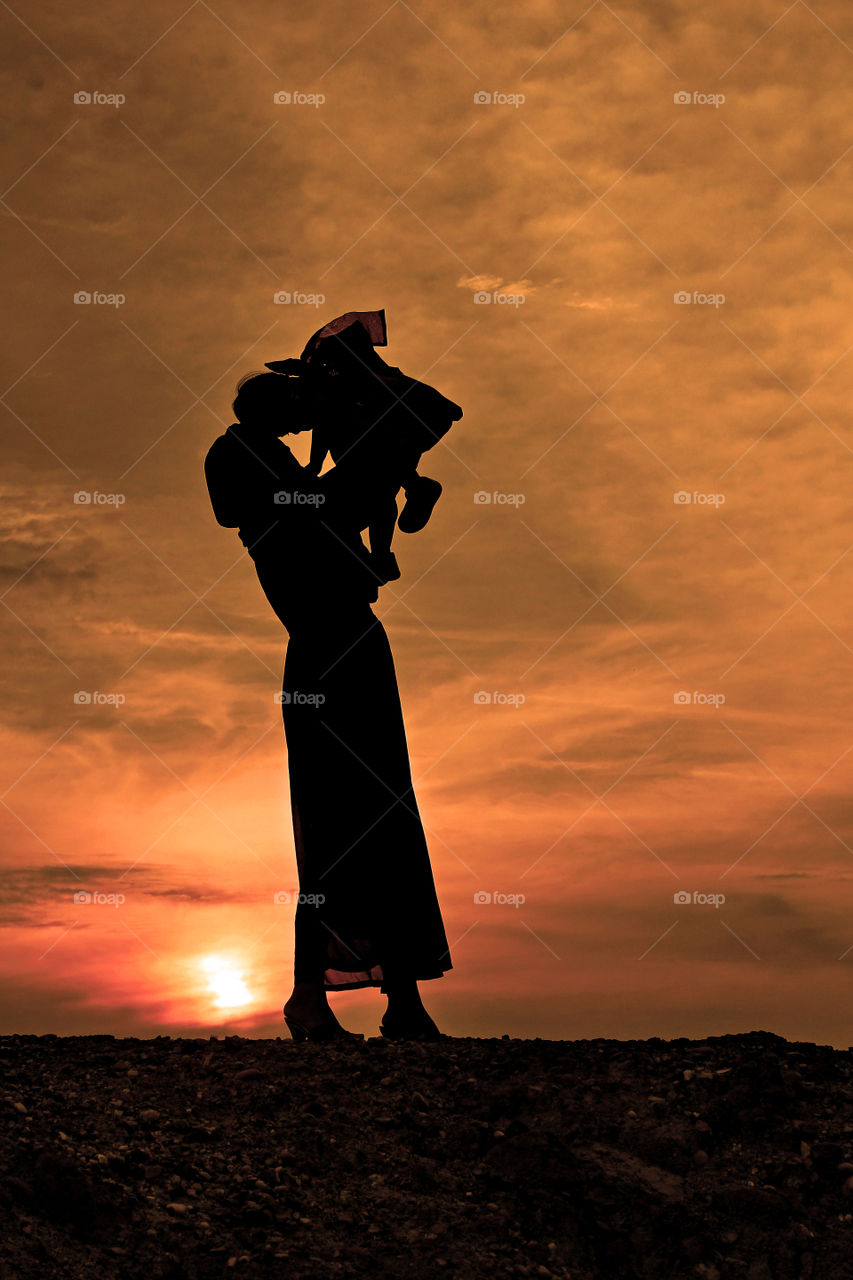 Mom and her kid under sunset at Banjarbaru, South Borneo, Indonesia.