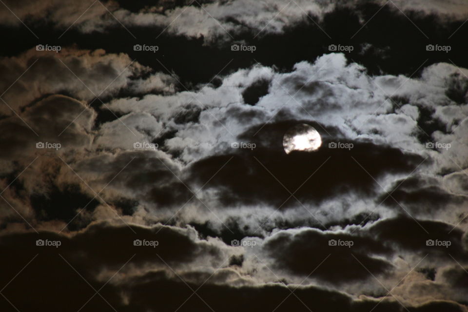 Moon behind dark cloud