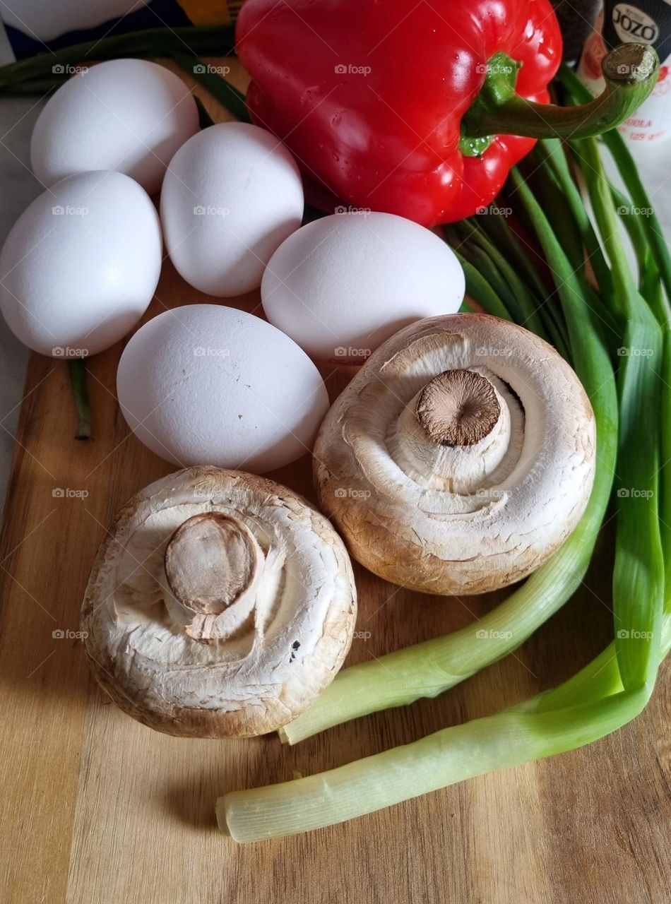an omelet with mushrooms, peppers, and spring onions
