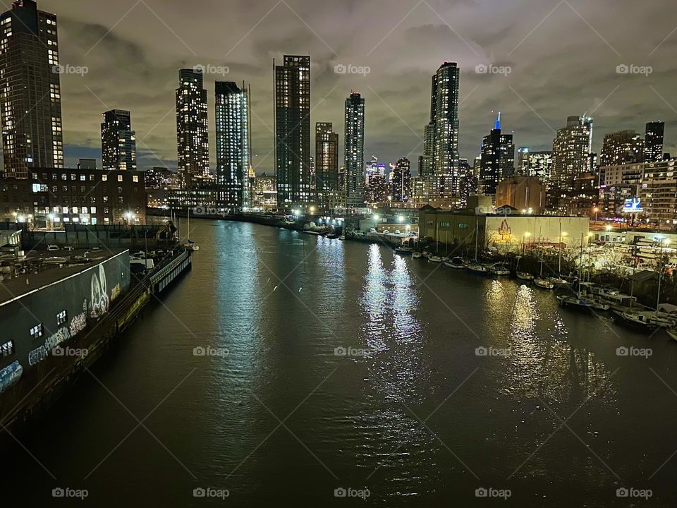 This is “Newtown Creek” at night seen from the “Pulaski Bridge” that connects “Greenpoint”, Bklyn and LIC, Queens presenting a good all around look at three boroughs of the “Big Apple”, NYC: Brooklyn, LIC and “Manhattan”. 2023 Hypnotic Productions