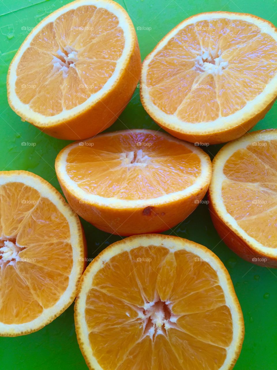 Orange. Sliced oranges on green surface