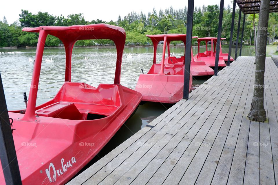 A boat that uses its legs to move in red floats on the water.