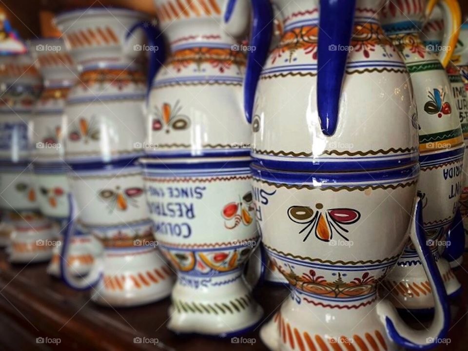 Hand-painted handmade Spanish ceramic sangria pitchers for sale stacked on top of each other.