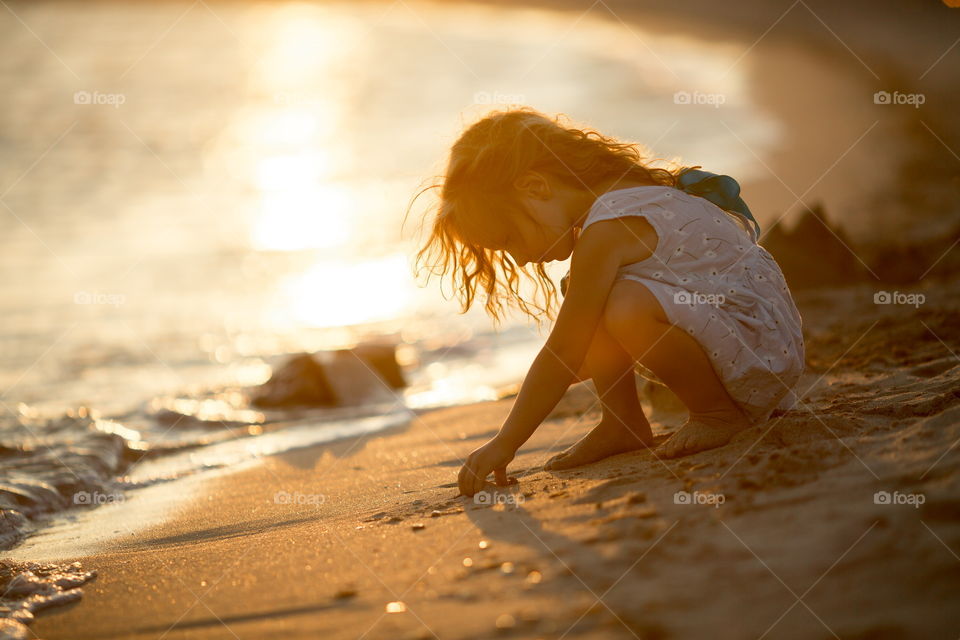 Little girl playing in the sand 