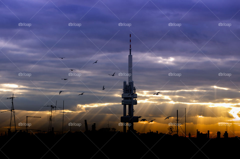 Rays of the sun shining through the clouds before sunset over the Zizkov Tower.