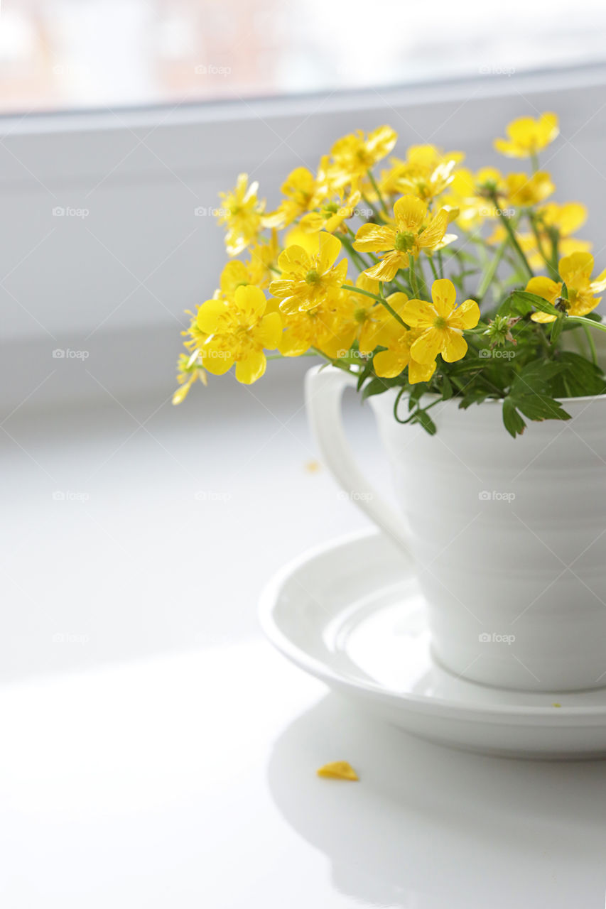 Coffee cup with yellow flowers on white background. Good morning!