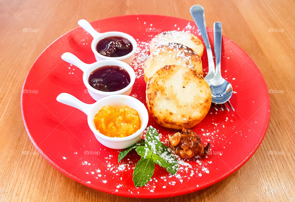 Pancake with cottage cheese and diverse types of homemade jam.