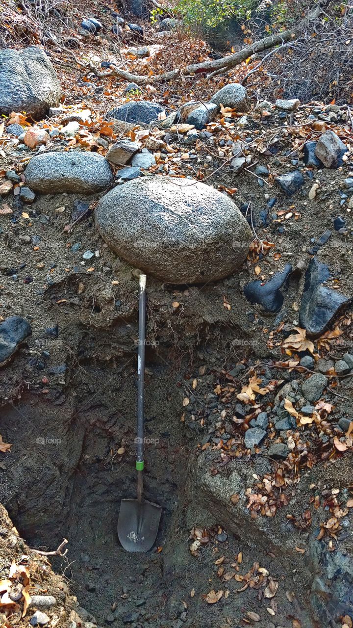 A Boulder Above This Dug Out Hole Creates A Dangerous Situation On A Rainy Wet Day.