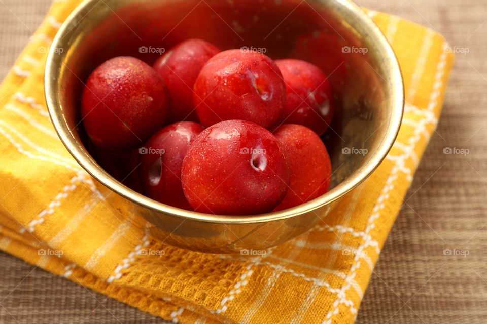 Fresh plums in a metal bowl