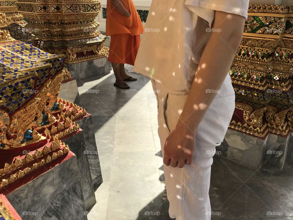 A girl and a monk near a buddist temple with  nice lights and reflections