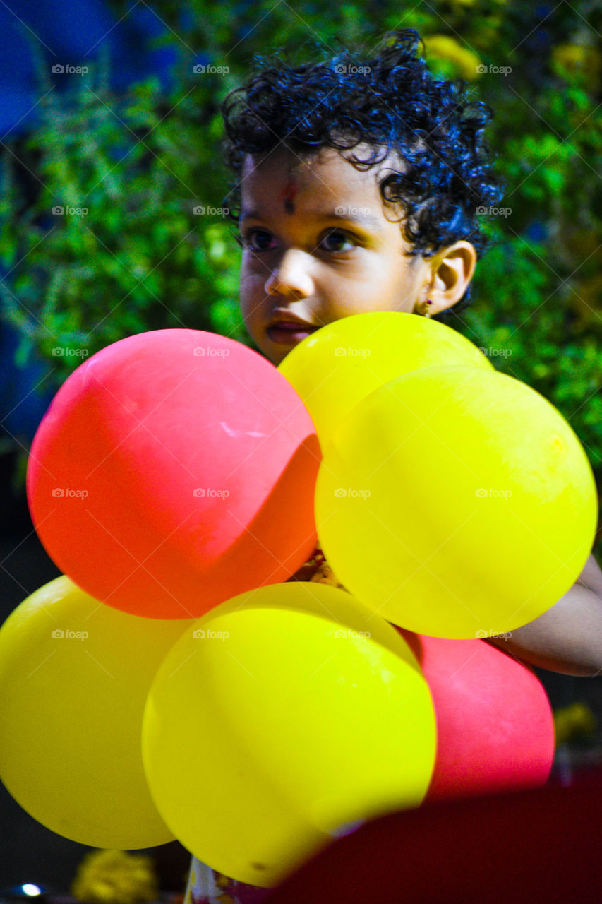 Kid playing with color color baloon.