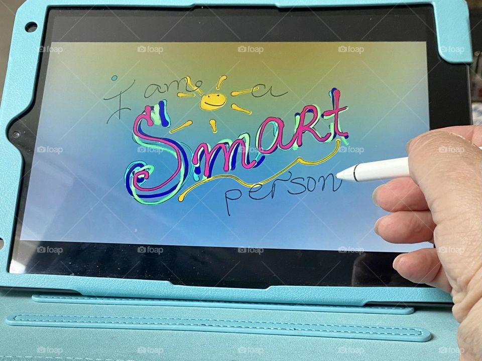 Drawing on iPad. Hand holding iPad drawing pencil 