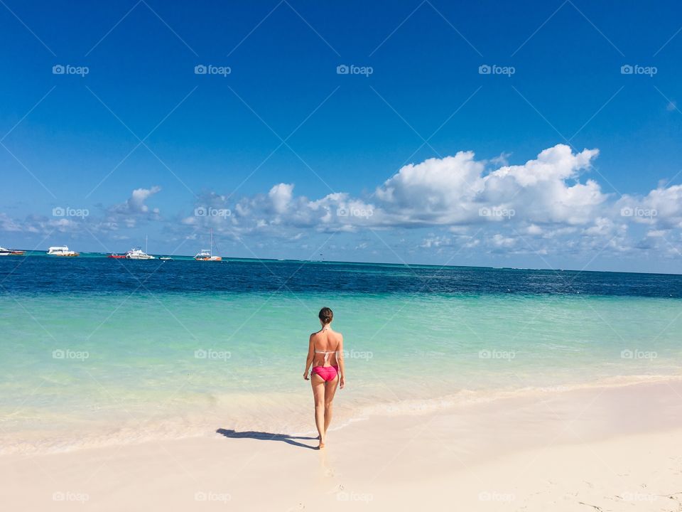 Girl on the beach in a crystal clear water