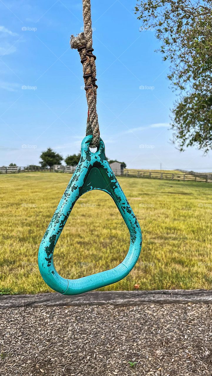 Old playground equipment for children, playground equipment on a farm, horse farms and playgrounds, closeup of an old ring on a playground, swinging around a farm