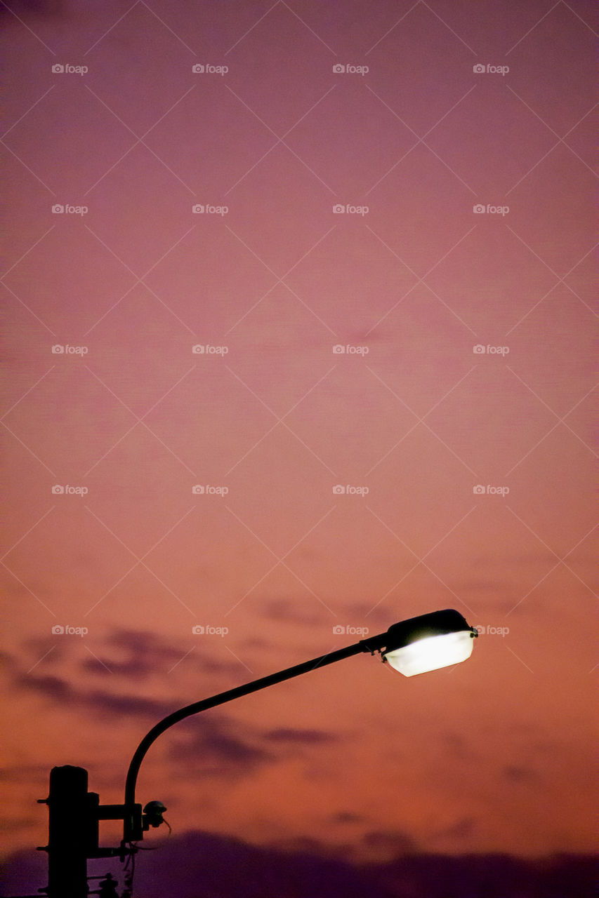 Street lighting and background sunset light reflected with the cloud.