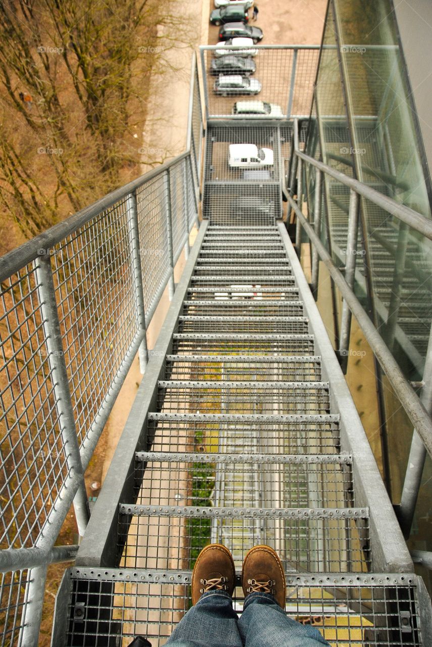 View to my feet and stairs of a high tower.