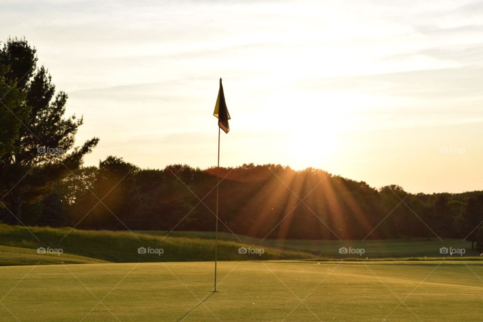 17th green at Sugarloaf . Sunset in the background if the flag pin on the 17th green at Sugarloaf the Old Course in Leelanau County's, MI