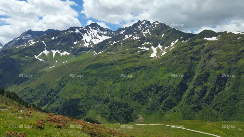 Bergpanorama mit interessanten Wolken Himmel blau und Schneefelder
